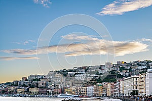 Wiew over fish boats embarked in the bay of Napoli on a gloomy spring evening. Napoli waterfront with Napoli hills and buildings