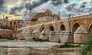 Wiew of the Roman Bridge Puente Romano and Umayyad Mosque Mezquita-Cathedral in the evening, Cordoba, Spain photo