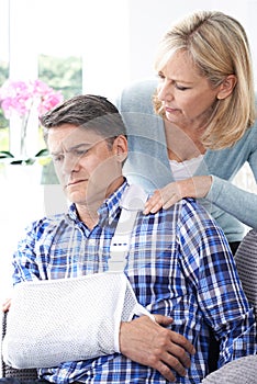 Wife Comforting Husband Suffering With Arm Injury