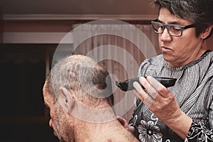 Wife cutting husbands hair at home photo
