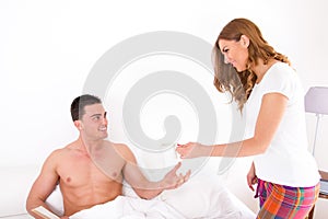 Wife giving husband coffee in bed