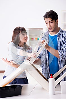 The wife helping husband to repair broken chair at home