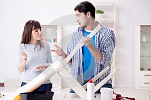 The wife helping husband to repair broken chair at home