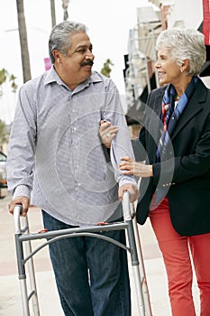 Wife Helping Senior Husband To Use Walking Frame