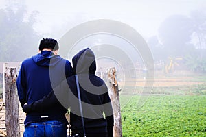 Wife hugging Husband to encourage each other to walk together in the mist of cool fog