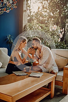 Wife and husband drink coffee together in hotel room in Thailand