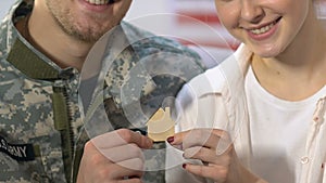 Wife and husband military uniform holding wooden house sign, ownership, mortgage