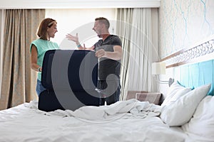 Wife and husband screaming on each other and argue, pack stuff in suitcase, couple fight