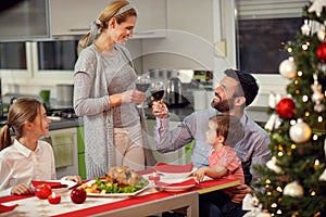 Wife with husband toasting with red wine during gala dinner