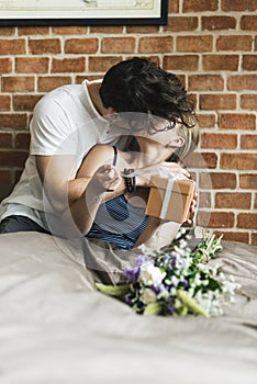 Wife receives a gift box and a bouquet of flower from husband