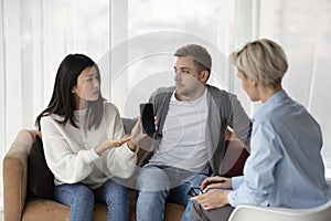 Wife Showing Cheating Husband`s Cellphone During Therapy Session In Office