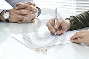 Wife signs divorce decree form with ring