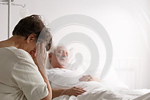 Wife sitting by dying husband