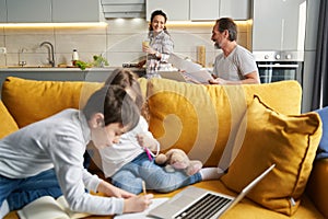 Wife smiling at husband while children doing homework