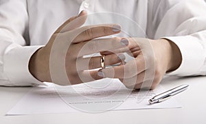 Wife in suit removing wedding ring from finger