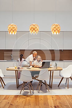 Wife support her husband sitting at table, man working with laptop from home