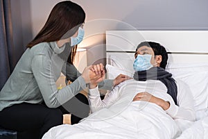 Wife take care her sick husband on bed at home, people must be wearing medical mask protecting from coronaviruscovid-19 pandemic