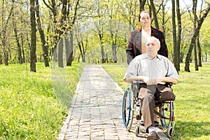 Wife walking a disabled man in a wheelchair