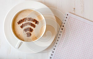 WiFi symbol made of cinnamon powder as coffee decoration on cup of cappuccino.