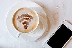 WiFi symbol made of cinnamon powder as coffee decoration on cup of cappuccino.