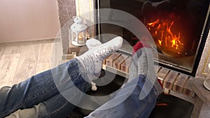 Wiggling legs in woolen socks heat up near fireplace