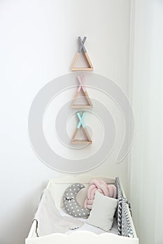 Wigwam shaped shelves over crib in baby room. Interior