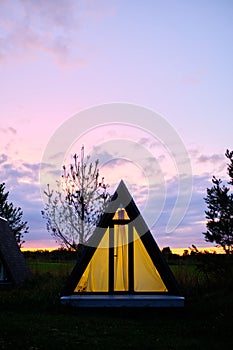 Wigwams against the sunset sky. A hause