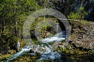 Wild Alpine River With Waterfall And Bridge In Austria