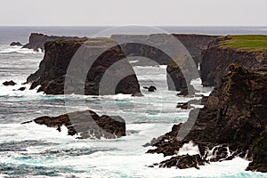 The wild Atlantic Ocean crashes against the sea stacks, rocks, and coastline