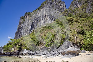 Wild beautiful beach on a small island with karst rocks in the Indian Ocean near El Nido