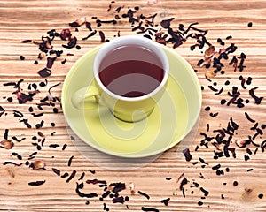 Wild berry tea in green cup with hibiscus leafs