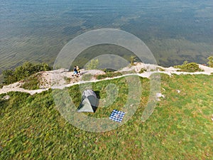 Wild camping in nature in Estonia. A young couple relaxes with a tent on the shore of the Baltic Sea in Paldiski on a summer