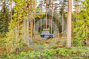 Wild camping in Sweden with 4x4 terrain car and roof tent in a natural forest
