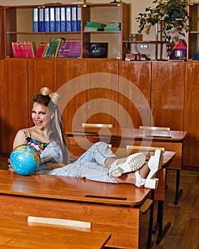 Wild Child in geography class with globe.