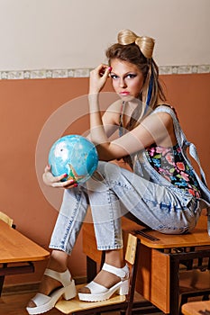 Wild Child in geography class with globe.