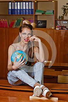 Wild Child in geography class with globe.