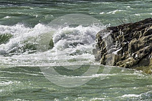 Wild and choppy river current breaking over rocks, aquamarine wa