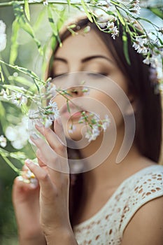 Wild flowers. Beautiful young woman portrait in flower field.