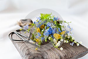Wild flowers on an old wooden board. lovely bouquet of wild flowers on a textured board. focus on the petals of a flower