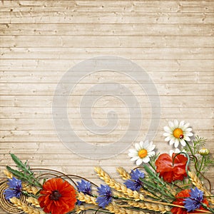 Wild flowers with spikelets on a wooden background