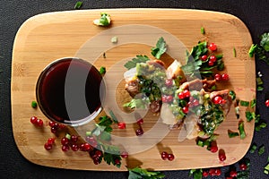 Wild fresh meat with greens and berries and wine. Meat on a wooden board.
