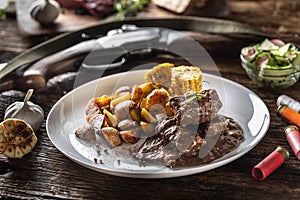 Wild game goulash stew served with roasted potatoes and seasoned with four colour pepper corn. Whole food is surrounded by hunting