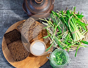 Wild leek pesto on a slice of bread with olive oil and salt on a wooden table with bread. Useful properties of wild garlic. Fresh