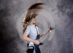 Wild musician with black guitar and flying hair