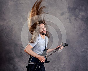 Wild musician with black guitar and flying hair