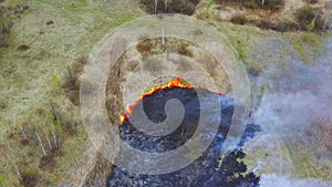 Wild Open Fire Destroys Grass. 4K Aerial View Spring Dry Grass Burns During Drought Hot Weather. Bush Fire And Smoke