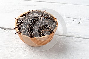 Wild rice in bowl on vintage wooden table