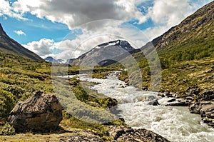 Wild river in the Jotunheimen National Park in Norway with mountain Styggehoe - way to the Spiterstulen settlement