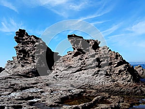 Wild sea rocks view against blue sky. Portoscuso, Sardinia Italy