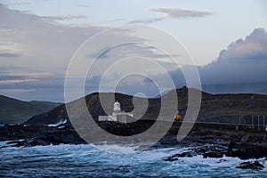 Wild sea and ruValentia Island's lighthouse in County Kerry, Ireland, view during dusk.